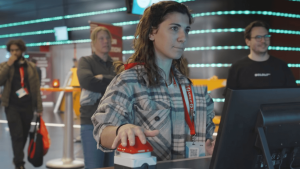 Vrouw drukt op een rode knop bij een beursstand